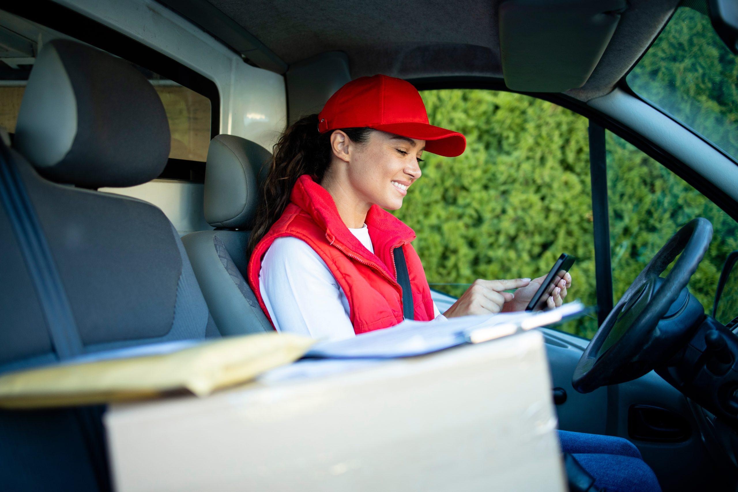 Female courier checking parcels on digital tablet