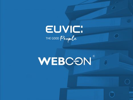 Logo Euvic i Webcon, w tle stos segregatorów